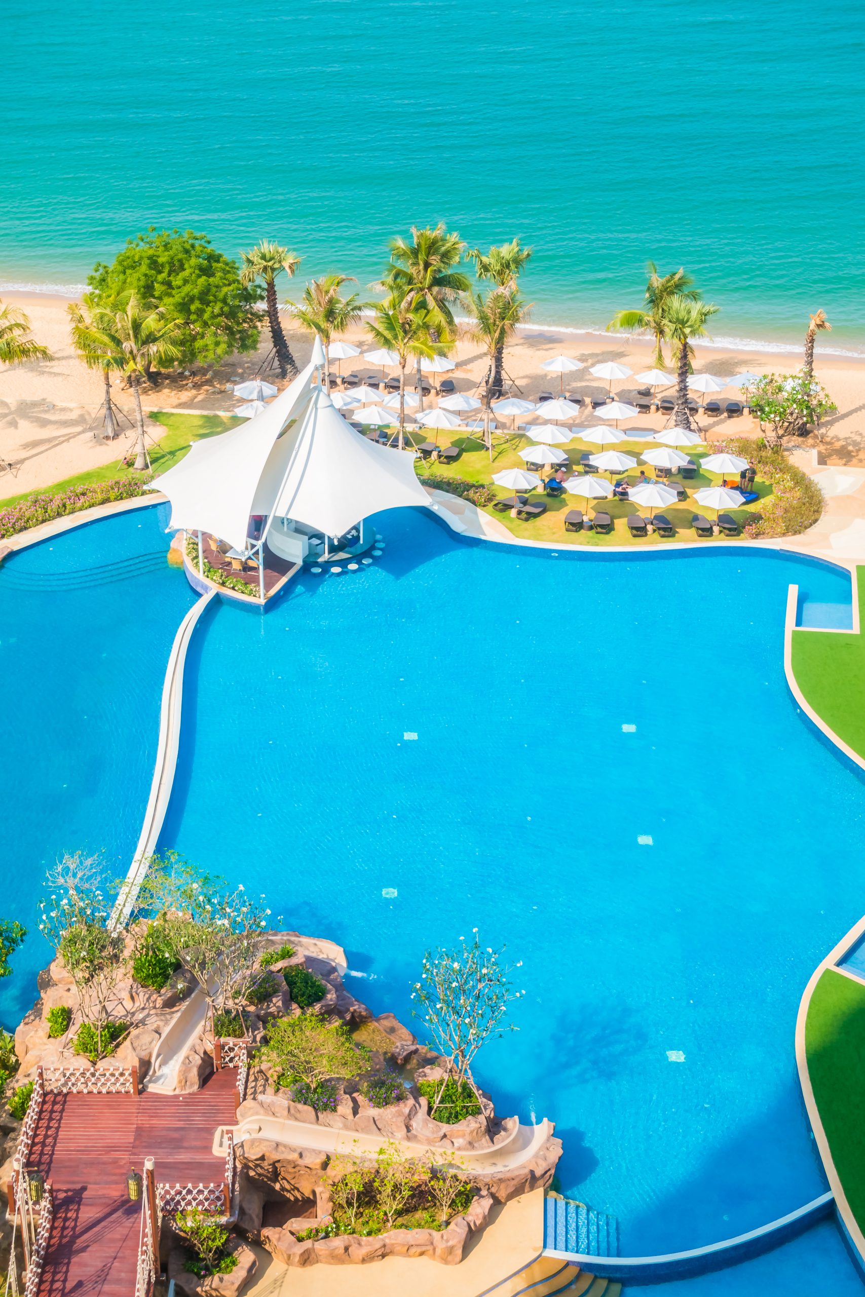 Aerial view of Umbrella and empty chair around swimming pool in hotel resort - Boost up color Processing